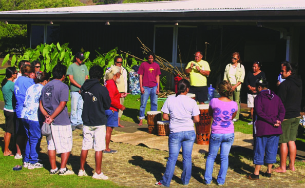 (‘IMI NA’AUAO: Learning)—HOEA students look at pahu niu (ritual drums carved from coconut trunks) created by their kumu (master teacher), Rodney Kala Willis.
