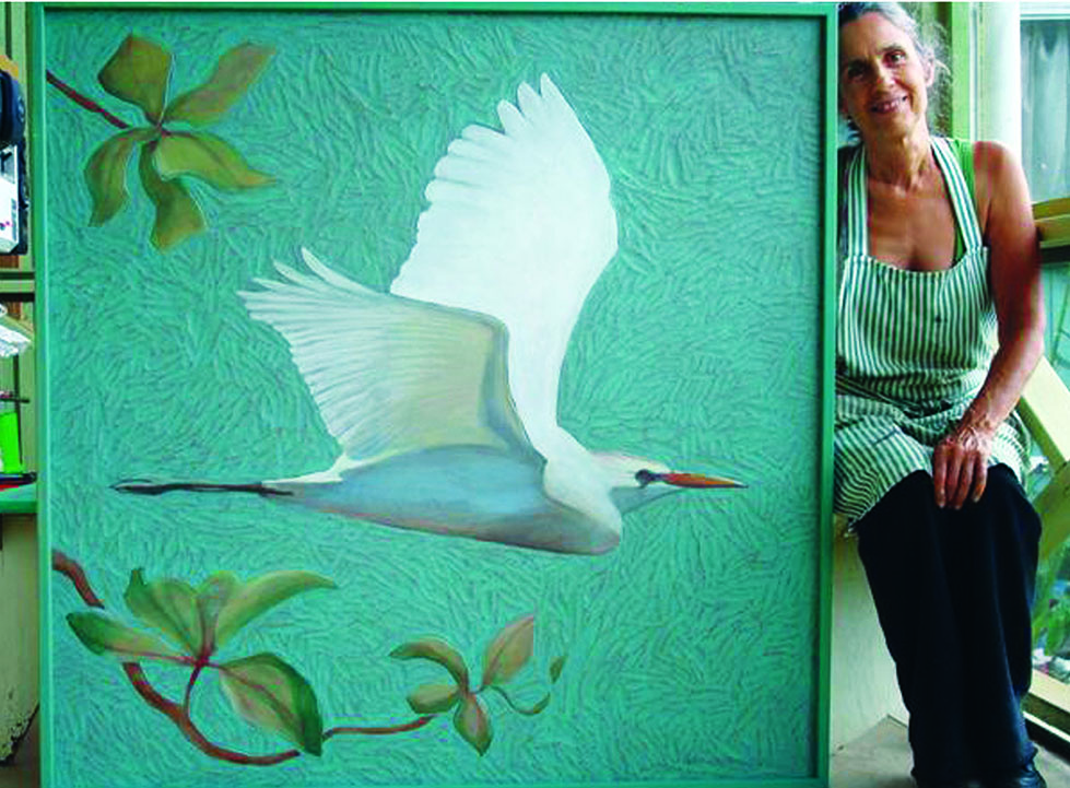 Suzy Papanikolas with one of her new series of bird paintings on carved Masonite.
