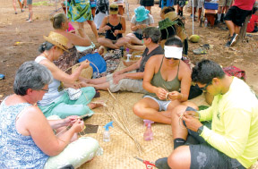 Lauhala workshop at annual Pu‘ukoholä Cultural Festival with club member Atsuko Kimoto at left wearing hat and teaching.