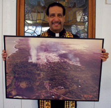 Kahu Mike Warren with a picture of the 1990 Kalapana lava flow approaching Kalapana Maunakea Church.