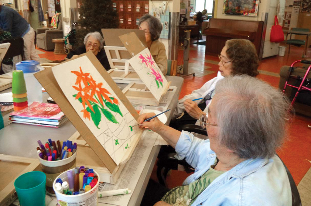 At a large table used for art activities, kūpuna create still life paintings. photo courtesy of HIAC