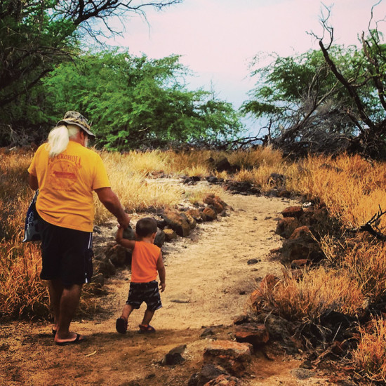 Tutu (grandfather) and mo‘opuna (grandchild) walking the Ala Kahakai Trail. photo by Pelika Andrade