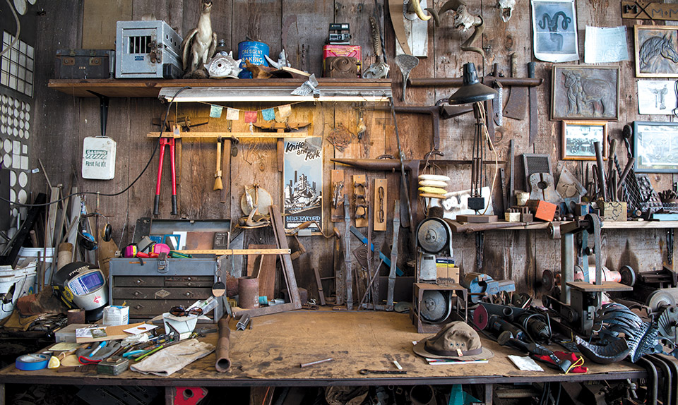 Tools from today and yesterday, photos and interesting found items fill a wall of the blacksmith shop. photo by Sarah Anderson