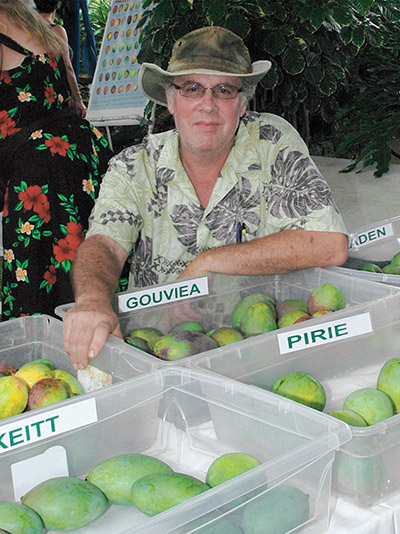 Ken Love of HTFG displays different Hawai‘i mangos at a past mango festival. photo by Fern Gavelek