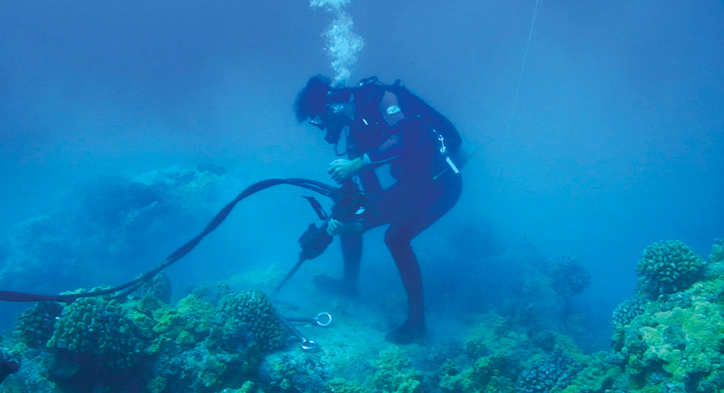 A diver drills a new mooring pin site.