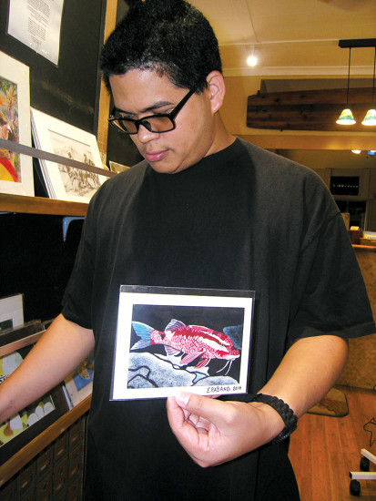 Elijah showing one of the many greeting cards he sells at Paradise Postal in Hāwi. photo by Jan Wizinowich