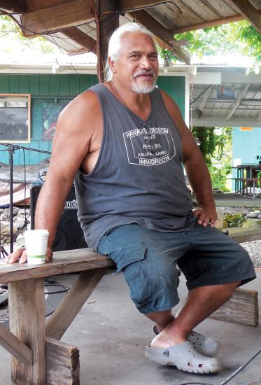 Uncle Samuel Keli‘iho‘omalu sits onstage at Uncle Robert's Farmer's Market. Uncle Sam was indispensable in the efforts to replant the New Kaimū Beach trail after the 1990 flow. photo by Stefan Verbano