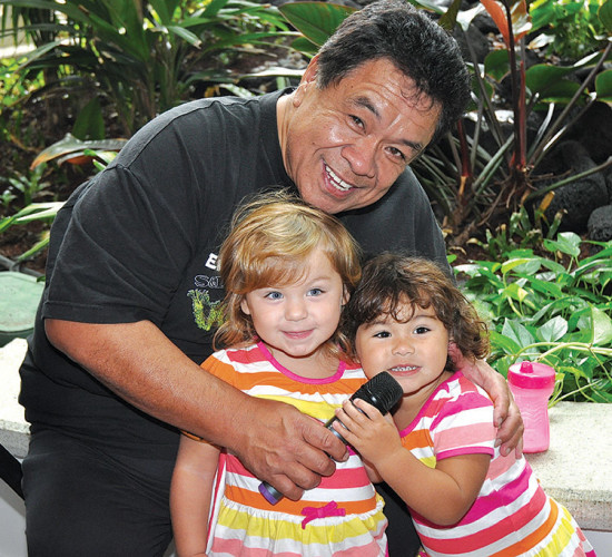 Sam takes a break with his twin granddaughters during the 2013 Keauhou Poke Contest. photo by Fern Gavelek