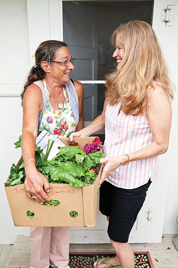 Lark Willey delivers a CSA box to customer Lisa Shattuck at her Waimea home.
