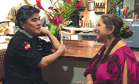 Chef Alan Wong talking story with GM Gayle Greco in September 2017 at the Hawaii Food & Wine Festival's chef's reception at Daylight Mind Coffee Company in Waikoloa.