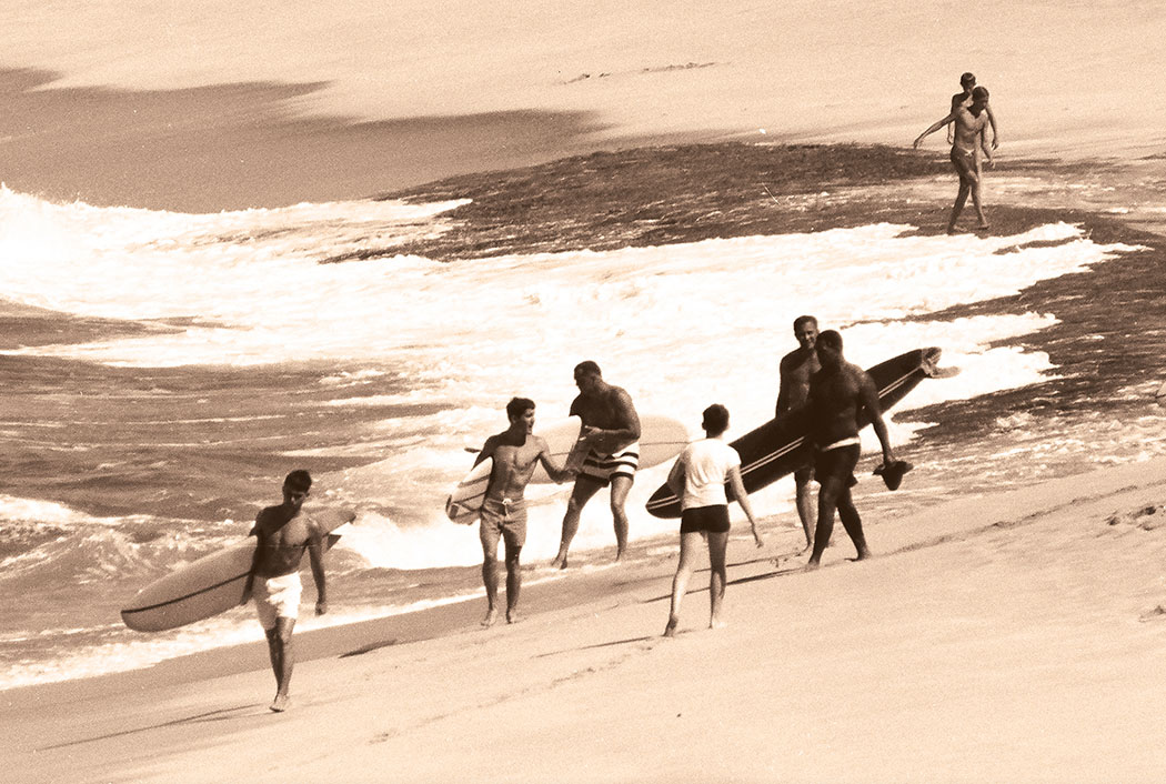 1966 2nd Duke Kahanamoku Invitational Surfing Championship competitors. L–R: Bobby Cloutier, 1965 Champion Jeff Hakman, Greg Noll, Kealoha Ka’io, and Jock Sutherland, at right-edge of frame, prepare to enter the water at Sunset Beach for their 45-minute heat. photo by Tim McCullough