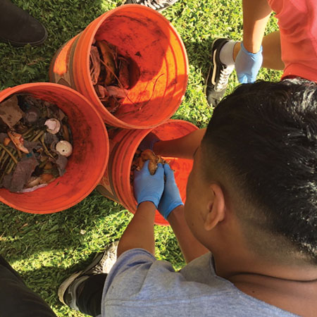 A student in the AP Biology class getting hands-on with bokashi. photo courtesy of Marcus Douglas