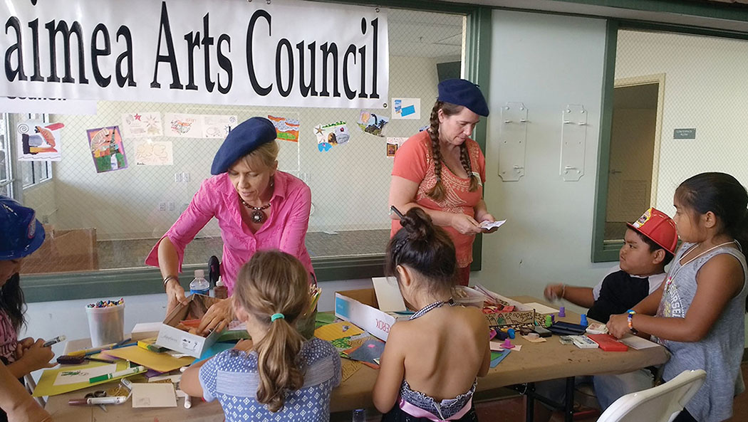WAC members Irina Place and Anna Sullivan work with young artists making collage at the 2017 annual Healthy Keiki Fest. photo courtesy of Julie McCue, WAC