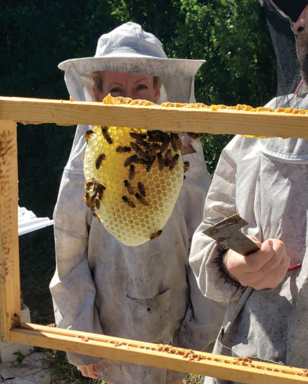 Ryan Williamson shows Sara Stover honeycomb being built in a hive in Na‘ālehu.