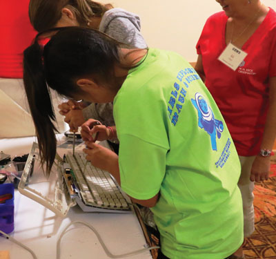 Fifth grade girl fixing a computer keyboard at a GEMS event. photo courtesy of AAUW Kona Branch