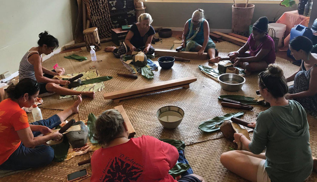 Kapa hui at the Hawaiian Cultural Center of Hāmākua to beat wauke. The women are at different stages of the beating process. photo courtesy of Puakea Fisher