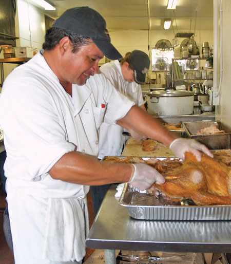 Jackie Rey’s culinary team of Executive Chef Muzzy Fernandez (front) and Sous Chef Justin Bensch tackle turkey carving for Thanksgiving.