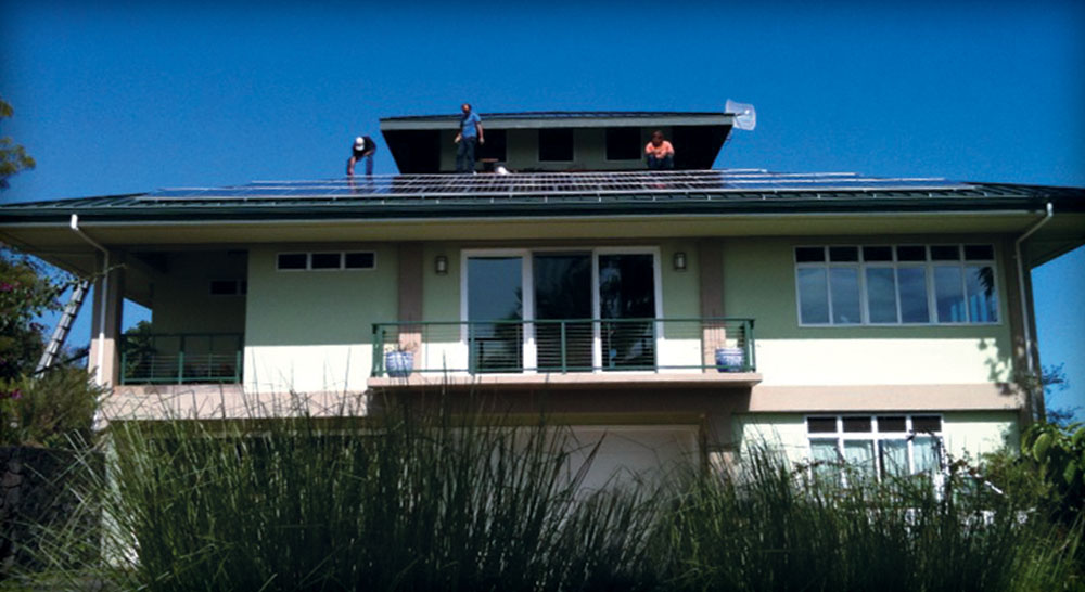 Solarman puts the finishing touches on the photovoltaic system installation for Michael Longo and Rob Nunally, who chose a grid-tied photovoltaic system for their home in Onomea.