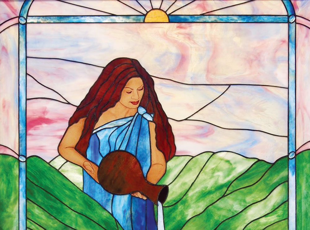 Calley O’Neill’s expertise in designing murals for public spaces is evident in her stained glass designs, such as “Water Bearer.”