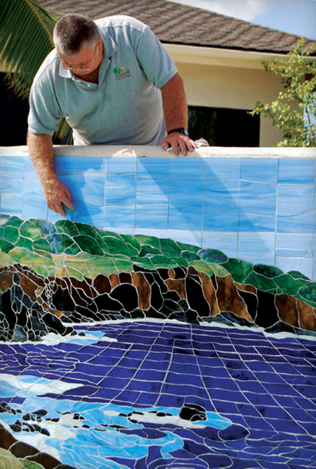 Master artisan Lamar Yoakum uses the stained glass methods perfected by Tiffany. Here he installs a curved mosaic design for a swimming pool.