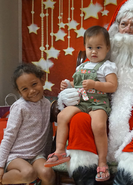 Santa giving keiki gifts at Project Hawai‘i holiday party. photo courtesy of Project Hawai‘i