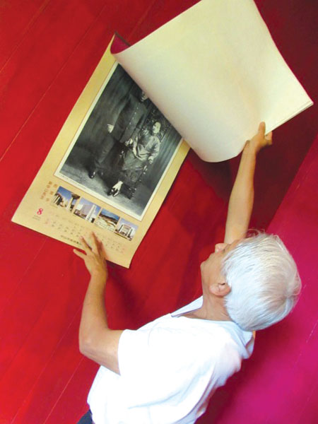 Clyde Wong flips through an old calendar of Sun Yat-sen photos. photo by Ma‘ata Tukuafu 
