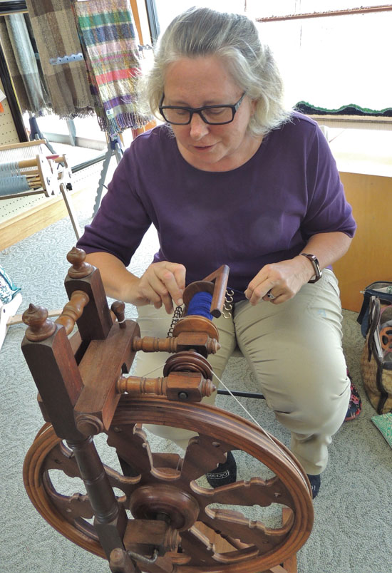 Hui member Joelle Dubois demonstrates using a spinning wheel to make yarn at the recent exhibition. photo by CTarleton